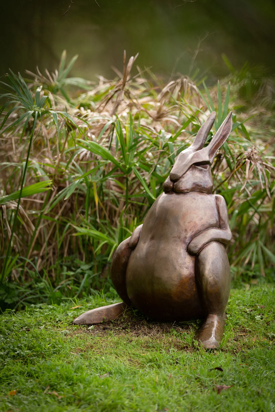 A bronze sculpture by Saskia Baetens, photographed outdoors on grass